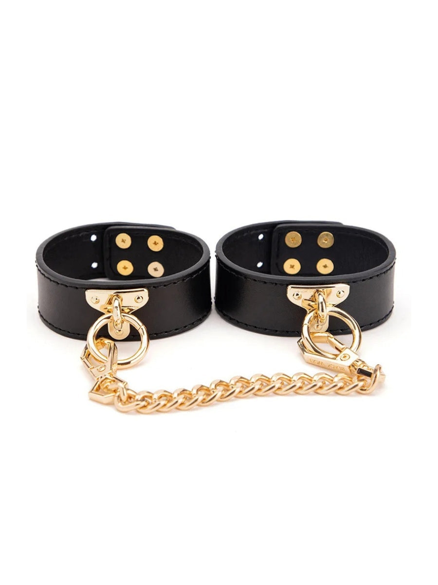 Black faux leather ankle cuffs with gold link chain and press-stud closure