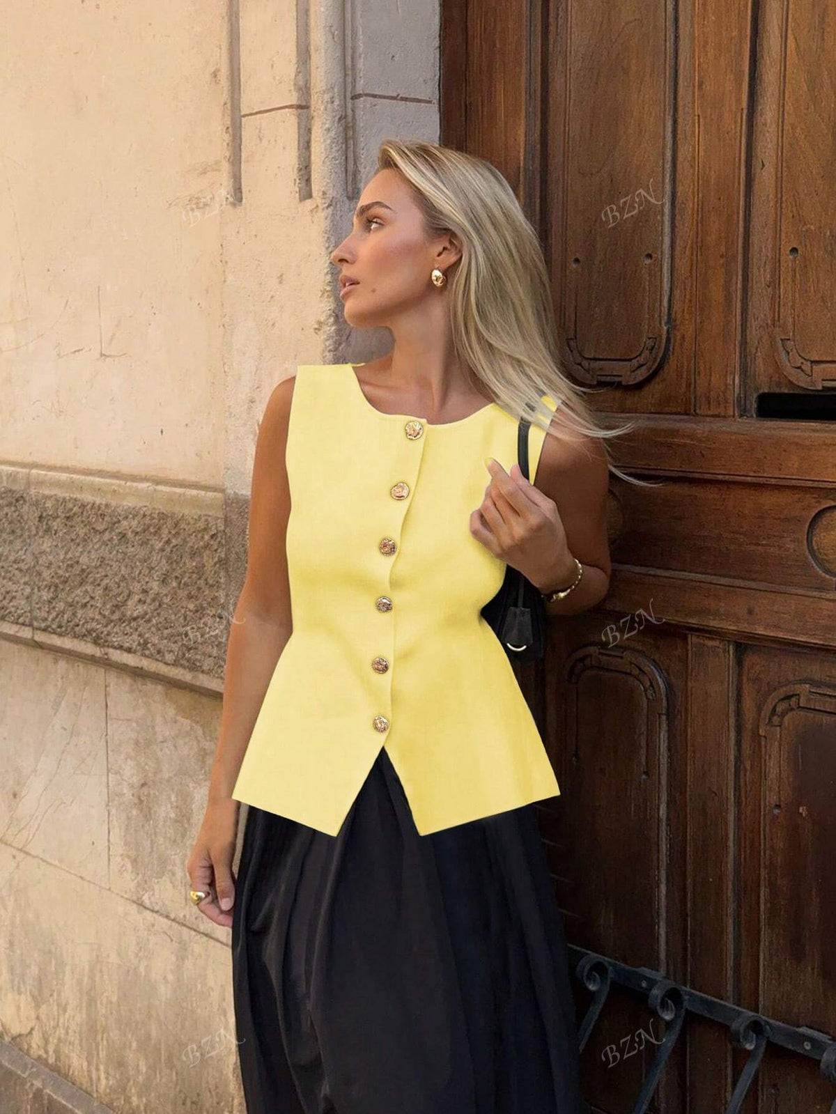 Women's sleeveless button-front peplum vest with gold buttons, tailored fit