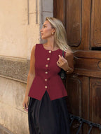 Women's sleeveless button-front peplum vest with gold buttons, tailored fit