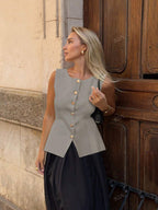 Women's sleeveless button-front peplum vest with gold buttons, tailored fit