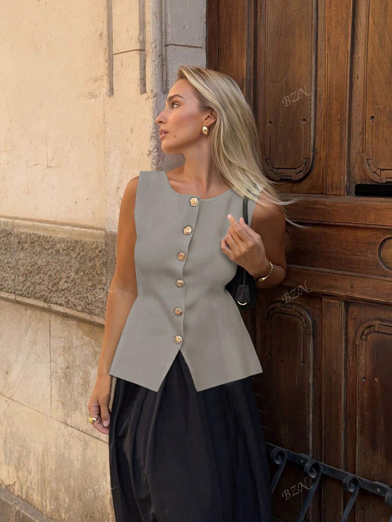 Women's sleeveless button-front peplum vest with gold buttons, tailored fit