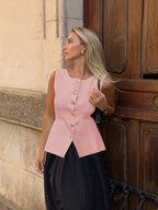 Women's sleeveless button-front peplum vest with gold buttons, tailored fit