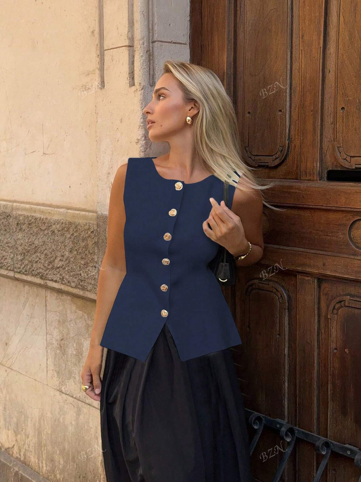 Women's sleeveless button-front peplum vest with gold buttons, tailored fit
