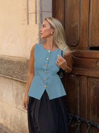 Women's sleeveless button-front peplum vest with gold buttons, tailored fit