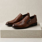 Men's leather dress shoes with lion embossed detail and side zip closure