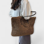 Women woven straw shoulder bag with firm top handle in natural texture