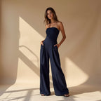 Women's strapless jumpsuit with fitted bodice and flowy wide legs, available in navy, black and beige