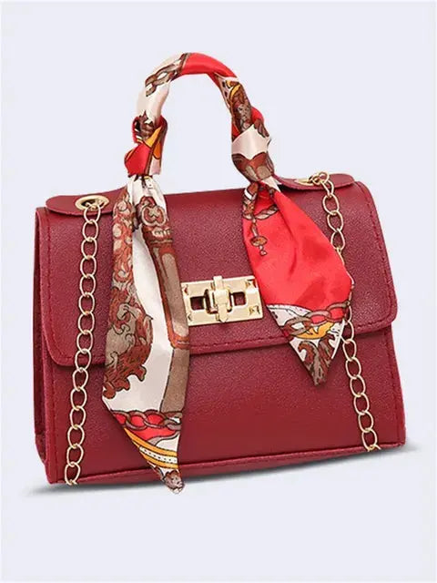 Women's brown leather handbag with gold clasp and scarf-wrapped handle
