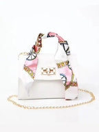 Women's brown leather handbag with gold clasp and scarf-wrapped handle