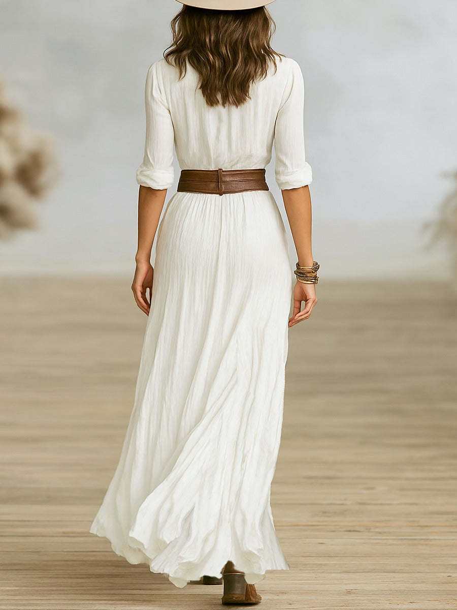 Women's long belted dress with pleated lapels and waist-defining adjustable belt