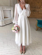 Women's white long sleeve flowing wedding dress with V-neckline, maxi bridal gown