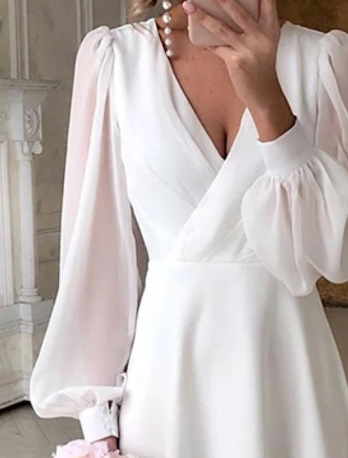 Women's white long sleeve flowing wedding dress with V-neckline, maxi bridal gown