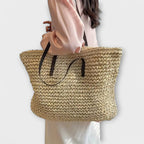 Women woven straw shoulder bag with firm top handle in natural texture