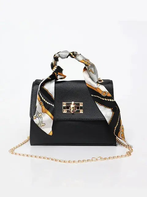 Women's brown leather handbag with gold clasp and scarf-wrapped handle